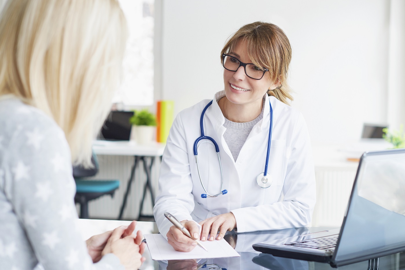DRK-Ärztin notiert etwas für ihre Patientin gegenüber