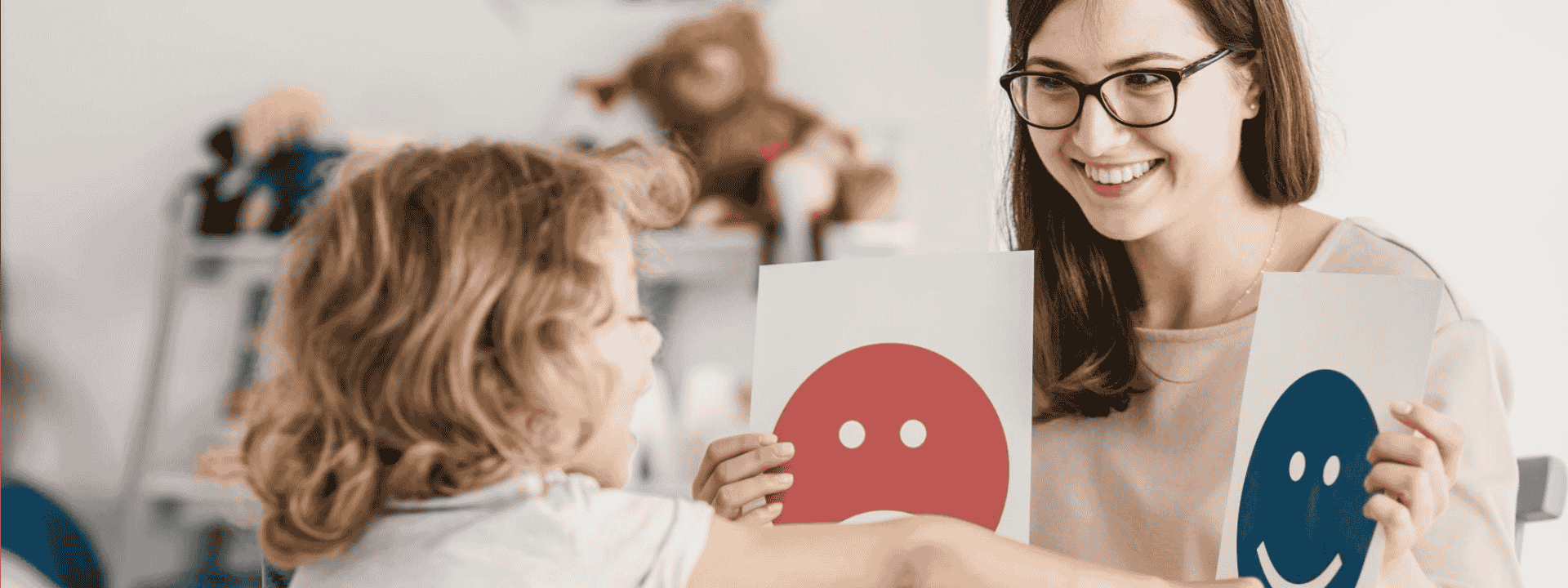 Psychologin sitzt gegenüber von einem Kind und betreut es