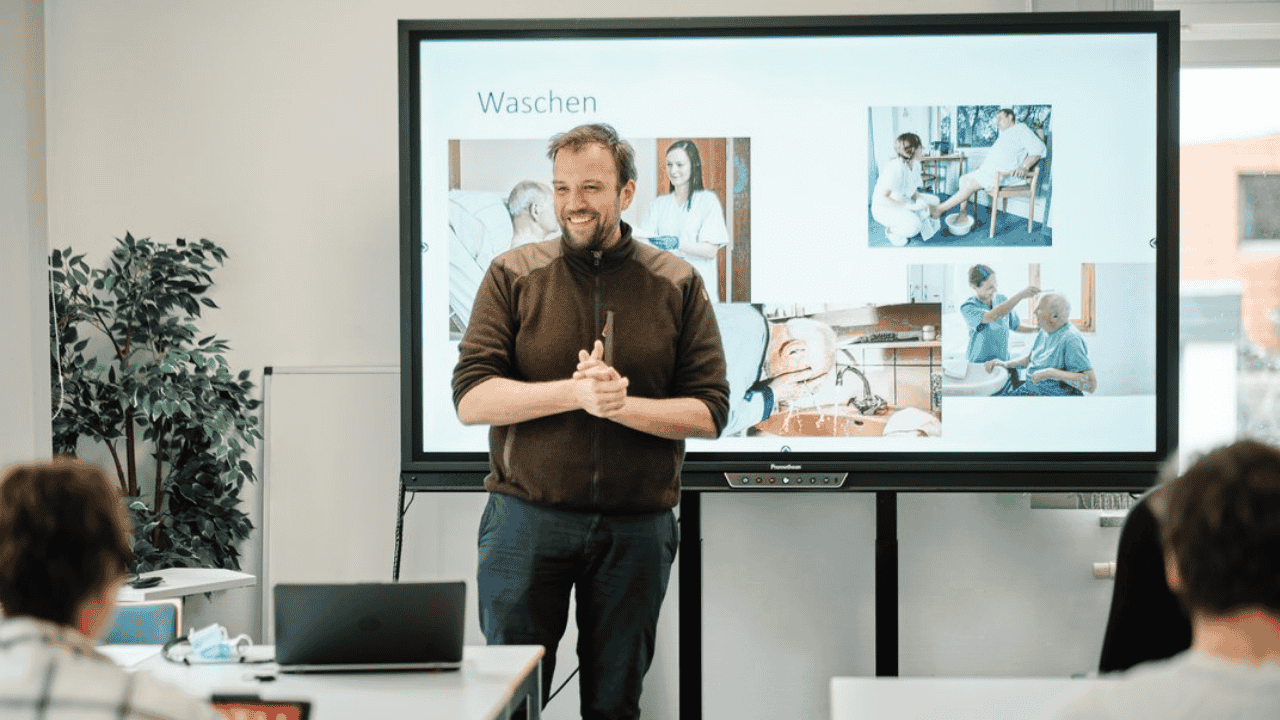 Dozent von der DRK Akademie SH steht am Whiteboard und unterrichtet